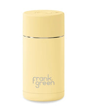 Load image into Gallery viewer, A pale yellow cylindrical travel bottle with a silver band and the 'frank green' logo printed on the front, set against a plain white background.
